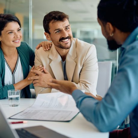 Happy couple talking to their financial advisor on a meeting in the office.